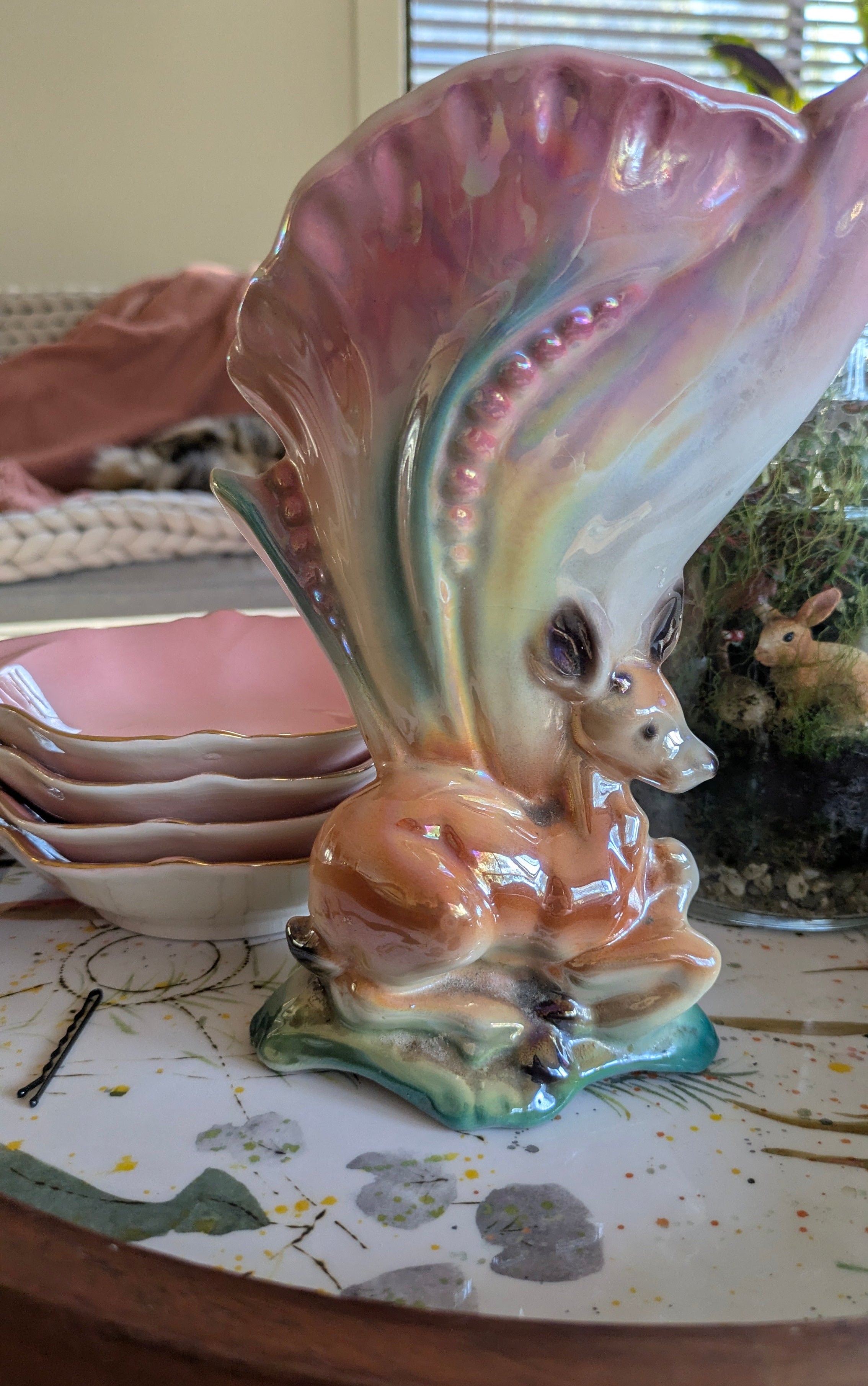 Ceramic shell with a small animal figure inside on a table.